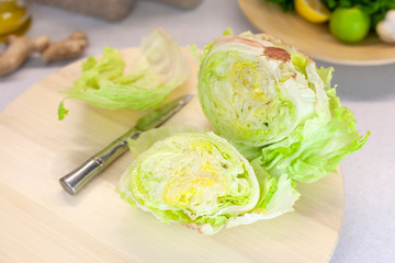 Closeup cut of iceberg lettuce on kitchen table on bright background