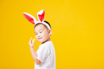 little children boy smile standing so happy bunny ears in Easter festival day holding easter eggs