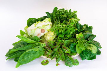 Bundles of salads on a white background isolated. Fresh greens: parsley, chard, dill, lettuce,...