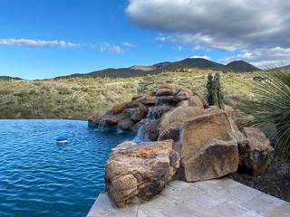 desert mountain pool with waterfall blue sky