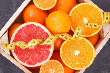 Fototapeta na wymiar Centimeter with healthy citrus fruits containing minerals and vitamins. Dieting and slimming concept