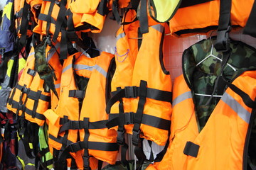 Bright marine life vest signal jackets close up, safety on water tourism activity and watersports