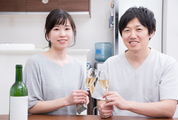 シャンパンで乾杯する若い夫婦