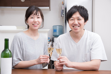 シャンパンで乾杯する笑顔の若い夫婦