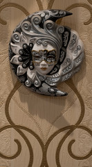 Black and white mask of the sun and moon with a face hanging on the wall