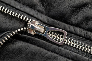 Fragments of a black artificial leather jacket with rivets and zippers. Background for clothes and...