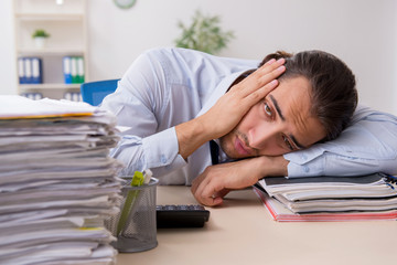 Obraz premium Young male businessman employee unhappy with excessive work
