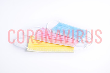 Color antiviral medical masks for protection against coronavirus. Yellow, pink and blue masks with translucent coronavirus lettering. 2019-nCoV virus infection. Novel coronavirus respiratory syndrome.