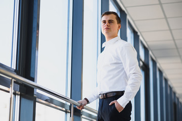 Handsome young businessman near window in office