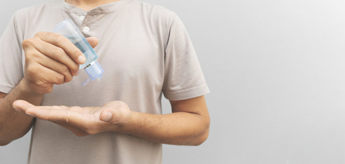 closeup man washing hands with alcohol gel 75% prevent virus and plague infection wihe soft-focus and over light in the background