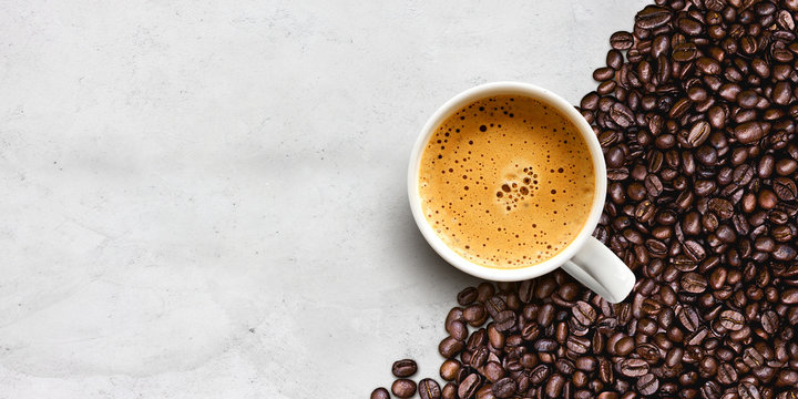 cup of coffee and bean on cement table background