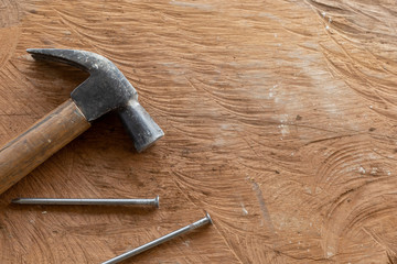 old hammer and  iron nail on wooden floor background. top view