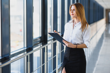 Portrait of stylish businesswoman near window in office