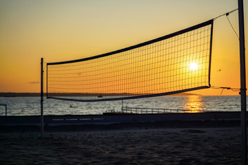 Fototapeta na wymiar Sillhouette of a volleyball net against sunset on the beach