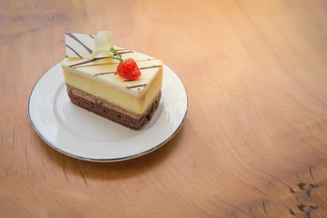 Fresh strawberry cheesecake on wooden table background. Selective focus on the front upper edge of the cake.