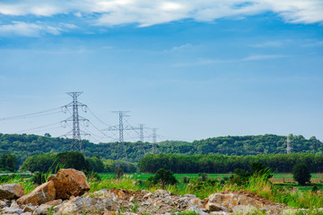 Obraz premium Electricity pole against sunset sky, Transmission line of electricity to rural with green tree, High voltage electricity pole with nature background, electricity transmission pylon