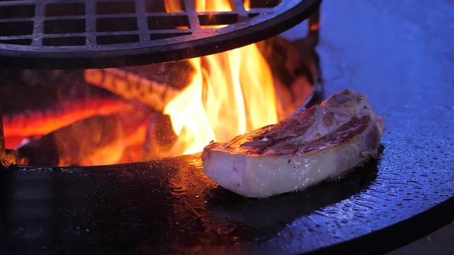 slow motion. steak fried on the surface of brazier. close-up