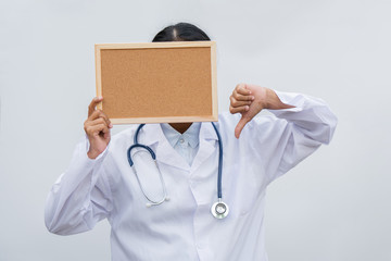 professional female doctor in white coat over white isolated background and white blank board and Thumbs down. Concept of healthcare, science and medicine concept