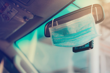 Hygienic masks hanging on the windshield on the inside of the car, where the sunlight comes in.protection from corona virus or COVID-19 concept.