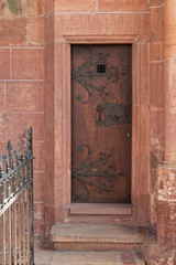 The old, medieval, wooden door with ornamental fittings