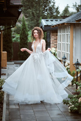Fototapeta premium Young bride wearing wedding dress and posing outside