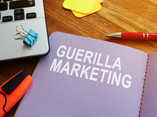 Guerilla marketing guide and laptop on the desk.