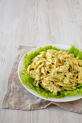 Homemade Coronation Chicken Salad on a white plate, low angle view. Space for text.