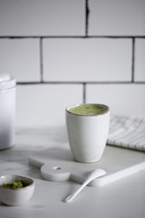 Matcha green tea latte in a rustic cup.