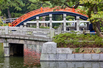 Curved bridge in the shrine garden with pond 