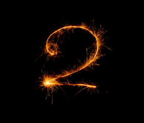 number two written with a sparkler on a black background