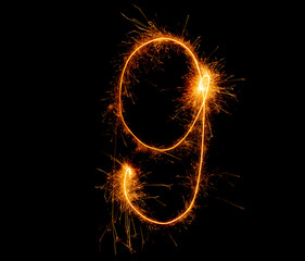 number nine written with a sparkler on a black background