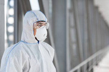 Man wearing protective biological suit and mask due to coronavirus