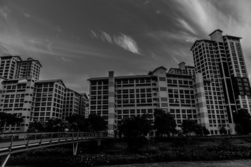 black and white image of streaking clouds behind the residential buildings