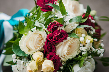 Gold wedding rings on the bouquet of flowers
