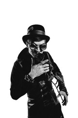 Steampunk actor in glasses and hat posing.