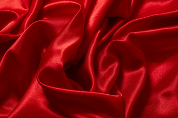 Obraz premium Luxury red satin smooth fabric background for celebration, ceremony, event invitation card or advertising poster