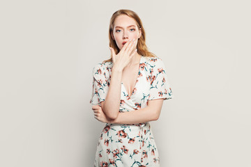 Shocked woman standing against white background