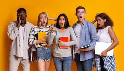 Stressed group of international students with alarm over yellow background
