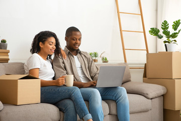 Couple searching for ideas sitting on sofa with boxes