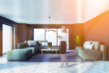 Obraz premium Woman walking in gray living room with sofa