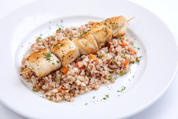 chicken kebab with buckwheat on the white plate