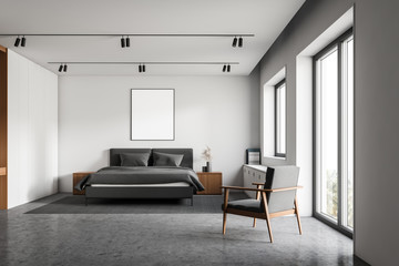 White master bedroom with poster and armchair