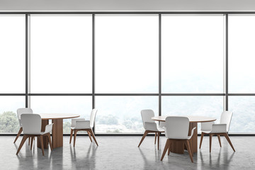 Round tables in panoramic white cafe