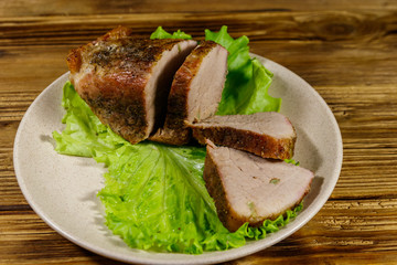Tasty baked pork with spices on a wooden table