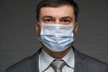a man puts a mask on his face for antivirus individual protection - healthcare and medicine concept, prevention tips