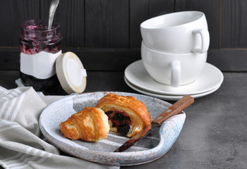 Tasty fresh croissant with jam on grey table