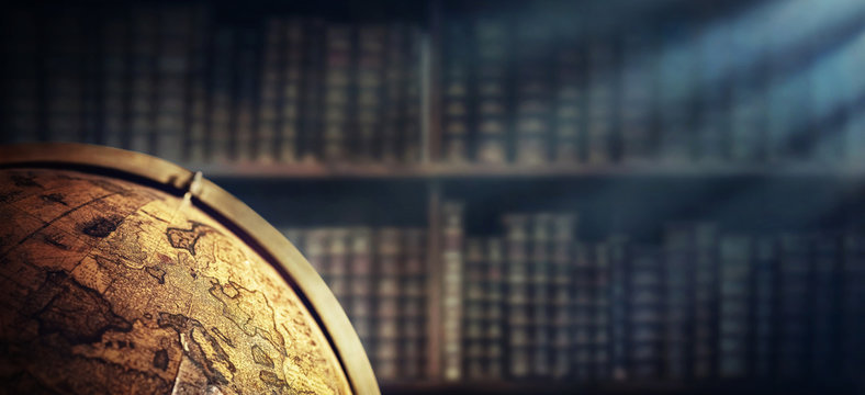 Vintage geographic globe on the background of bookshelves. Science, education, travel, vintage background. History and geography team.