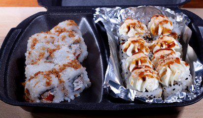 Rolls and sushi in a single container. food delivery to your home.