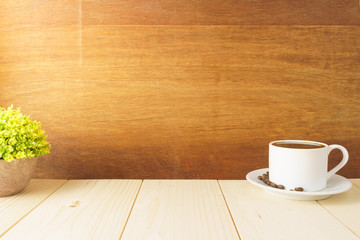Fototapeta na wymiar coffee cup with beans and office supplies on wooden desk against wood background. copy space for your text