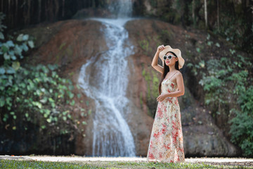 Fototapeta na wymiar Beautiful woman in dress by the waterfall